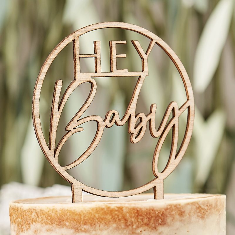 Runder Holzcaketopper mit dem Schriftzug Hey Baby.