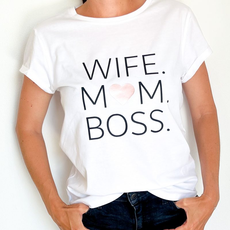 T-Shirt in weiß aus Baumwolle mit dem Aufdruck über die gesamte Brust mit Wife Mom Boss. Das o von Mom ist ein Herz.